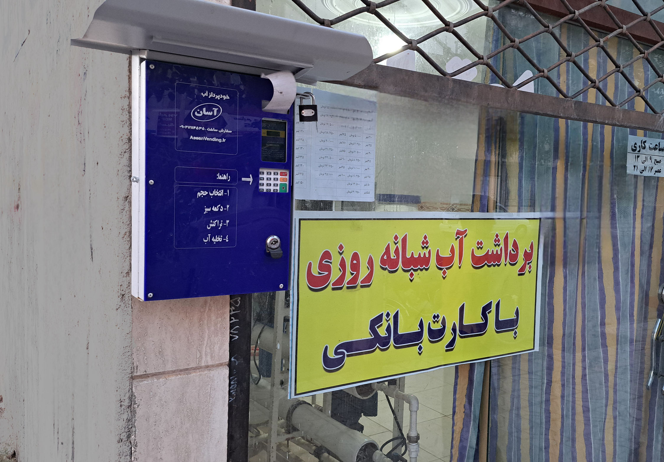 نمونه نصب شده دستگاه فروش آب  آسان دیواری کنار شیشه سکوریت